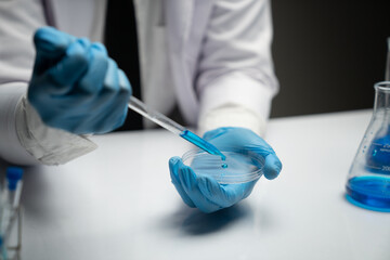 scientist Working in the laboratory using a Micro Pipette. Mixing liquid chemicals with genetically modified samples under a microscope biotechnology, microbiology development, research experiments.