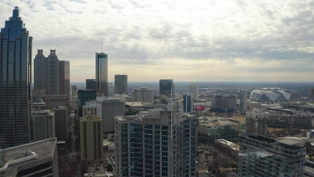 Slow moving aerial drone shot flying above the skyscrapers in downtown Atlanta, Georgia on a cloudy day in the winter.