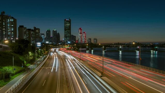 Timelapse of Night Traffic on Olympic Daero Expressway with Yeouido FInancial District Buildings and 63 Building Tower View, Subway Train Crossing Han River - panning hyperlapse