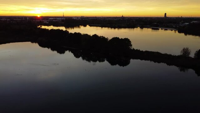 Silhouettes of trees and water during the golden sunset from high above.