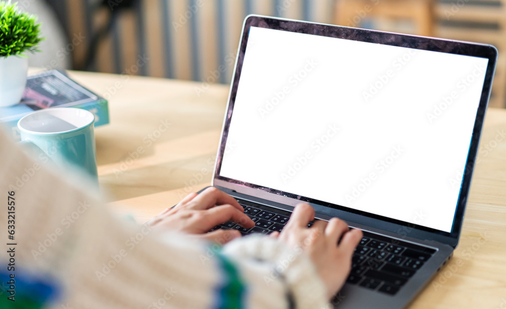 Wall mural woman working with modern laptop computer blank white desktop screen for advertising, mockup, techno