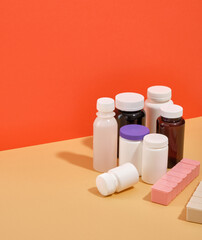 Many different shaped and colored medicine jars on the table. Boxes for pills and copy space for text.