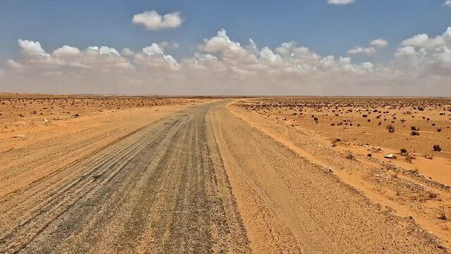 Wind blowing sand on desert road in Tunisia. Driver point of view while driving, slow motion