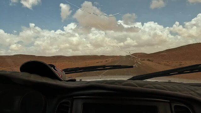 Wipers Dry Windscreen From Raindrops As Car Drives On Desert Road In Tunisia, Driver Point Of View