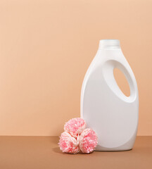 Laundry detergent in a white bottle on a beige background. Copy space for text. Cleanliness and...