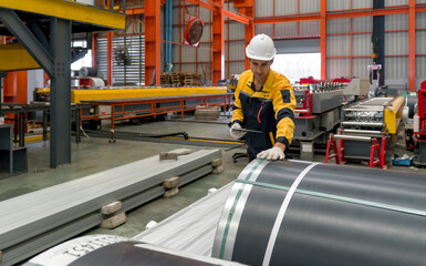 Industrial diligent worker safeguarded by a hard hat, engrossed in his duties amidst the complex...