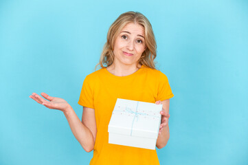 Portrait of dissatisfied sad woman holding gift box or present