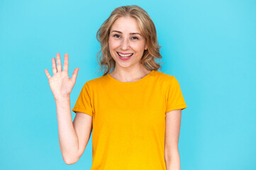 Portrait of smiling woman waving hand and saying hello