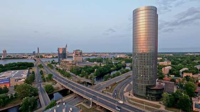 Time lapse of cars driving through intersection crossing river boats, sunlight reflects on tower, riga latvia