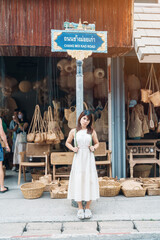 Young asian woman traveler in dress with hat traveling to wicker shop on Chang Moi Kao Road,...