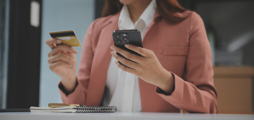 .Women holding credit card and using smartphones at home.Online shopping, internet banking, store online, payment, spending money, e-commerce payment at the store, credit card, concept