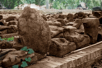 The broken remains of an ancient 20th-century Buddha statue in sepia tone