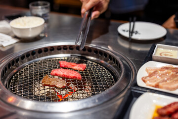 Grill beef meat on the metal net in Japanese restaurant