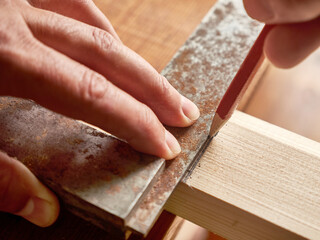 With the help of a handkerchief, a wooden board is marked. Carpentry works. A tool for marking wooden blanks.