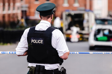 PSNI officers close a street in Belfast, allowing ATO from the "bomb squad" to deal with a suspected bomb.