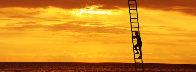 silhouette of businessman boy with backpack climbing a ladder over big sea. sunset sky on background. © Maxim Chuev
