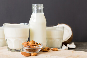 Set or collection of various vegan milk almond, coconut, cashew, on table background. Vegan plant based milk and ingredients, top view