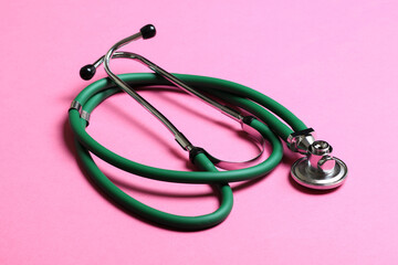 Top view of green stethoscope on colorful background. Medical diagnosis tool concept