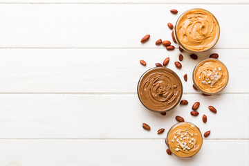 Glass jar with peanut butter on table background, top view space for text and close up