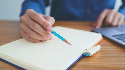 A hand holding a pen and signing a document