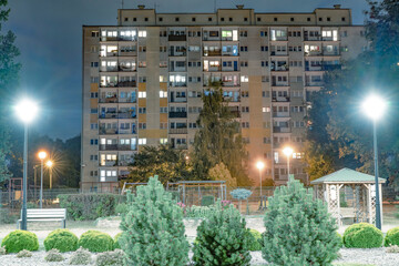 Wieżowiec na tle osiedlowego ogródka nocą © Mariusz