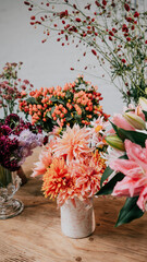 Different flowers on table on different looking vase