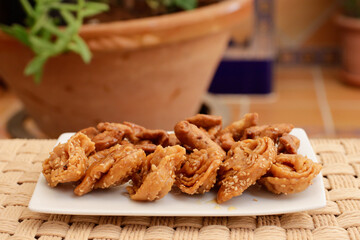 Moroccan chebakias on a white plate in a patio with plants