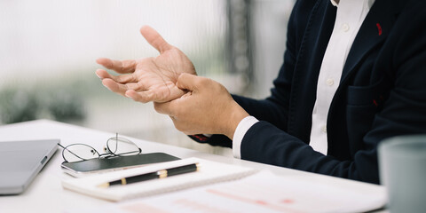 Businessman have wrist pain after work hard in office feeling so pain and illness with Office syndrome symptom, healthcare office syndrome concept.