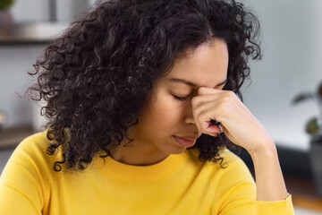 Portrait of an African American woman suffering from headache after hard working day, migraine...