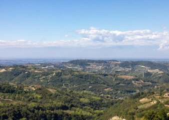 View of the Langhe-Roero hills and vineyards in Piedmont with the Alps in the background. Italy