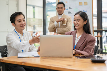 Obraz premium A happy Asian businessman is sharing his ideas, discussing work with a female colleague