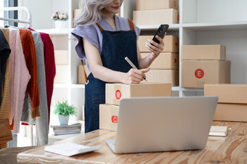 Young Asian female woman starting SME small businesses owners to be entrepreneurs, business woman smile and use tablet computer notebook for sell product online making marketing internet online