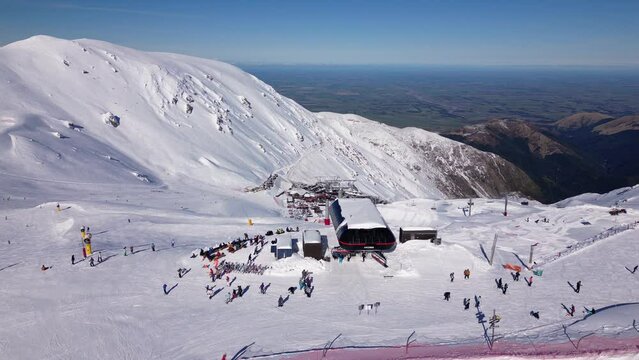 Mt Hutt, New Zealand: Aerial drone footage of people riding a chair lift in the Mt Hutt ski resort in  the Canterbury region on a sunny  winter day in New Zealand south island