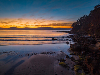 Fototapeta na wymiar Pretty sunrise at the seaside with high cloud and low tide