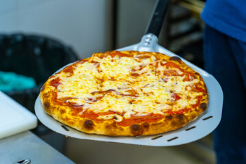 Person holding a delicious cheese pizza