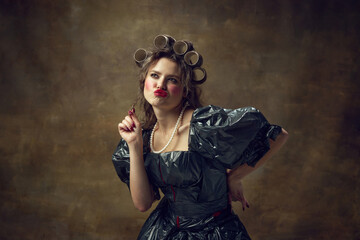 Queen. Portrait of dreaming woman dressed in paper tube wig and black dress made of garbage bags...