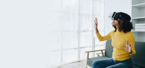 Positive African American woman teenager in futuristic VR helmet laughing and relaxing. Youthful girl is delighted with high-tech video games and virtual reality gadgets sits, Artificial Intelligence