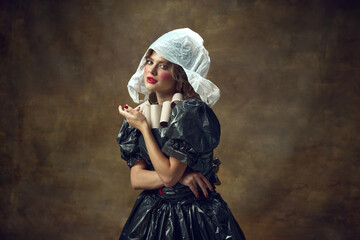 Queen. Portrait of elegance woman wearing white plastic hat, black dress made of garbage bags and...