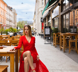 beautiful girl in a red dress at a table in a cafe