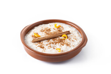 Arroz con leche. Rice pudding with cinnamon in clay bowl isolated on white background