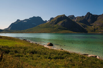 View of the blue sea in Lofoten, with mountains in the background