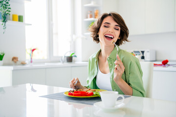 Photo of shiny funky lady dressed green shirt enjoying fresh meal laughing indoors house kitchen