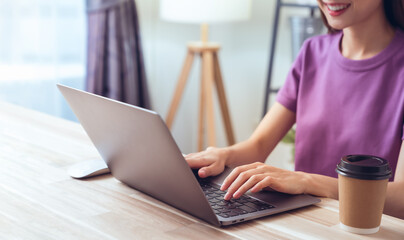 Woman using laptop and hand typing on the computer keyboard in the office.