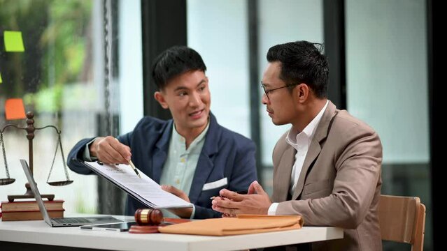 Asian business team and lawyers discussing contract papers sitting at the table. Concepts of law, advice, legal services. at modern office