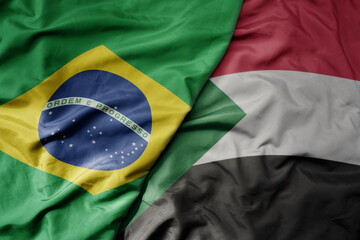 big waving realistic national colorful flag of brazil and national flag of sudan .