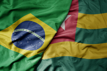 big waving realistic national colorful flag of brazil and national flag of togo .