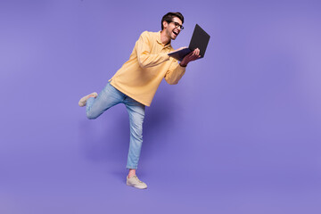 Fototapeta na wymiar Full length body photo of crazy hardworking young man it specialist profession browsing laptop hp brand isolated on purple color background