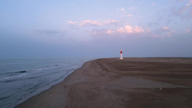 Aerial view approaching Fangar Lighthouse in Delta del Ebro beach with epic sky
