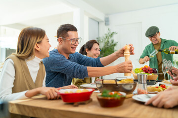 Group of Cheerful Asian man and woman eating food and drinking wine celebration dinner party...