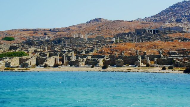 view from the sea of the ancient monuments and ruins on the sacred island of Delos, Greece. The birth place of god Apollo.